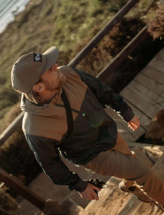 A man wearing THE ONE™ jacket and a KÜHL cap