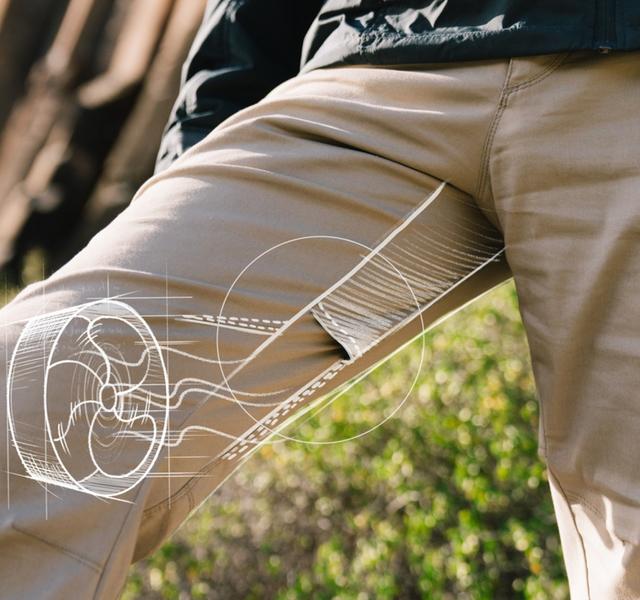 Man wearing KUHL pants while hiking with illustration detailing breathability.