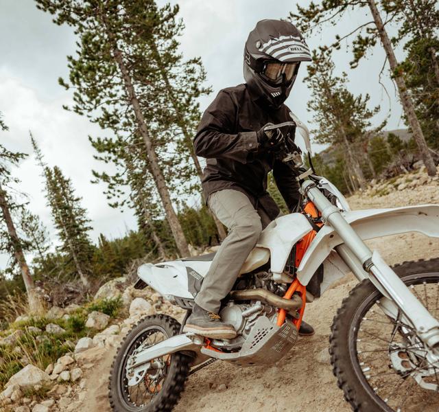 A man riding a bike wearing Renegade Recon pants.