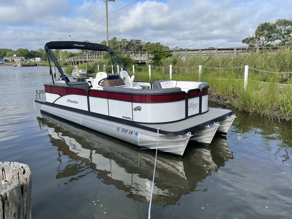 red and white tritoon on body of water