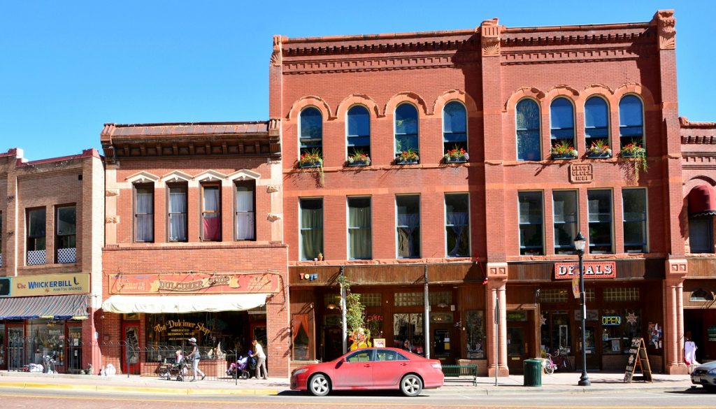 red car in front of red brick buildings 